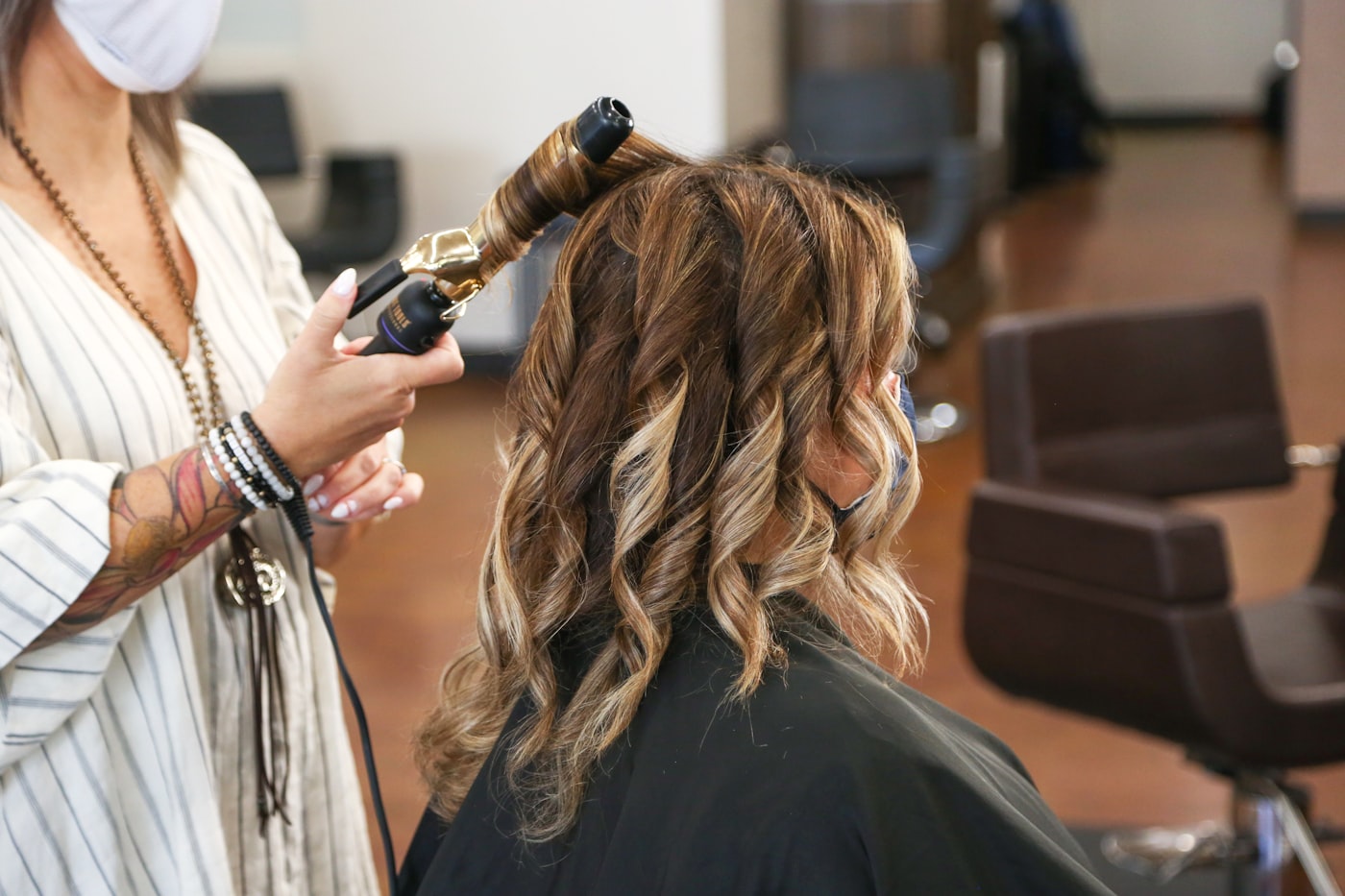 A stylist finishing an upstyle in a busy salon